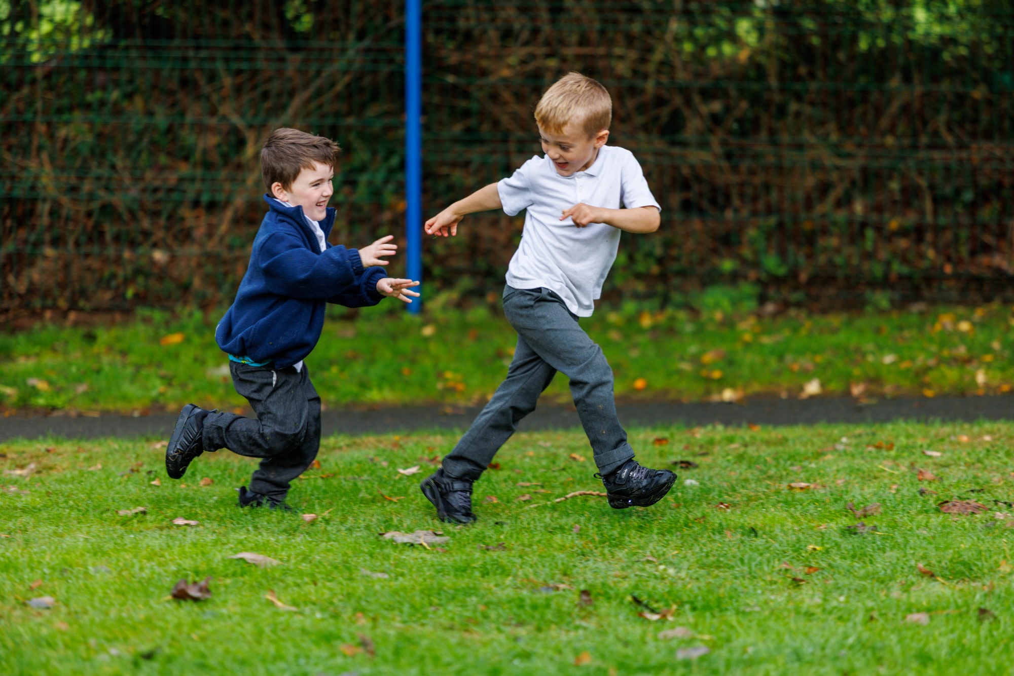 Two children running in the school feild at Mevagissey Community Primary School